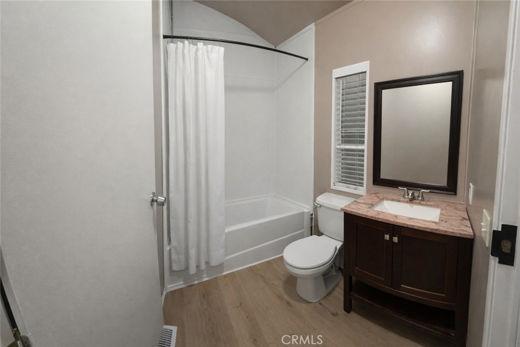 135 North Pepper Avenue, Unit 7 Rialto, CA 92376 - Photo 6 of 8 a bathroom with a toilet a sink and a mirror