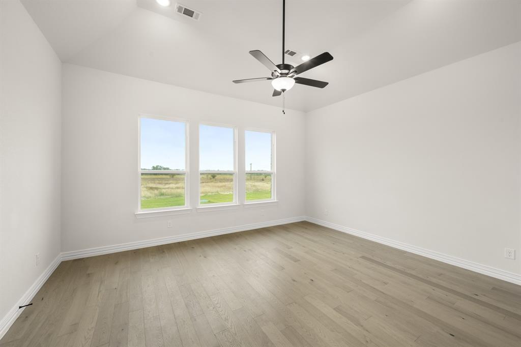 211 Marie Lane Waxahachie, TX 75167 - Photo 16 of 24 an empty room with wooden floor fan and windows