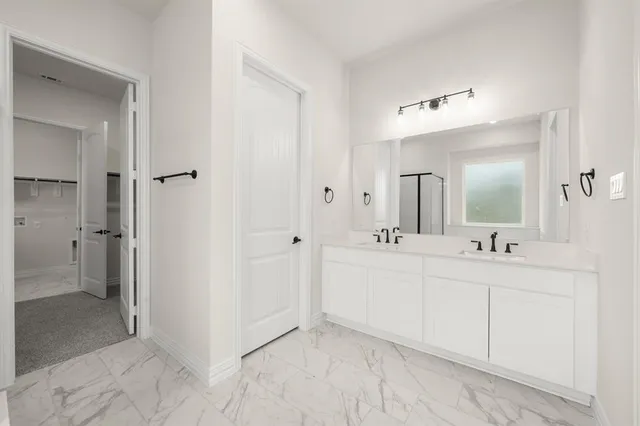 a bathroom with a double vanity sink mirror and shower