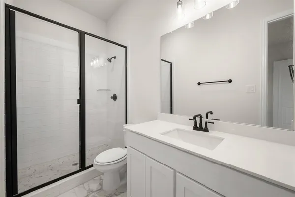 a bathroom with a sink a toilet and shower