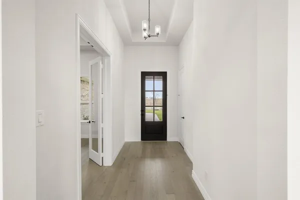 a view of a hallway with wooden floor and staircase
