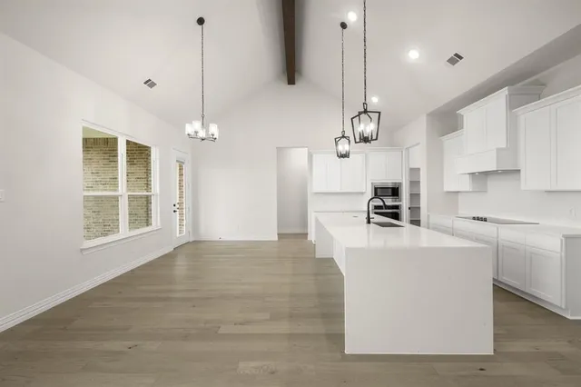 a large kitchen with kitchen island a stove a sink a center island a stove and a window