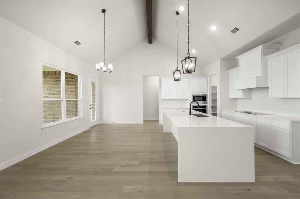 211 Marie Lane Waxahachie, TX 75167 - Photo 6 of 24 a large kitchen with kitchen island a stove a sink a center island a stove and a window