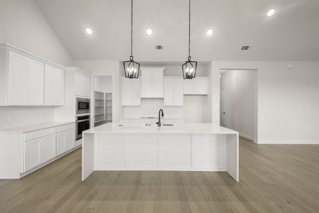 211 Marie Lane Waxahachie, TX 75167 - Photo 8 of 24 a view of a kitchen with kitchen island a sink stainless steel appliances and cabinets