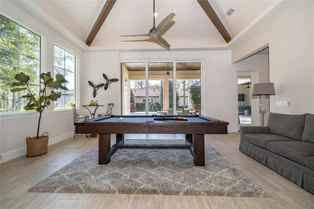 a living room with couch a flat screen tv and a floor to ceiling window