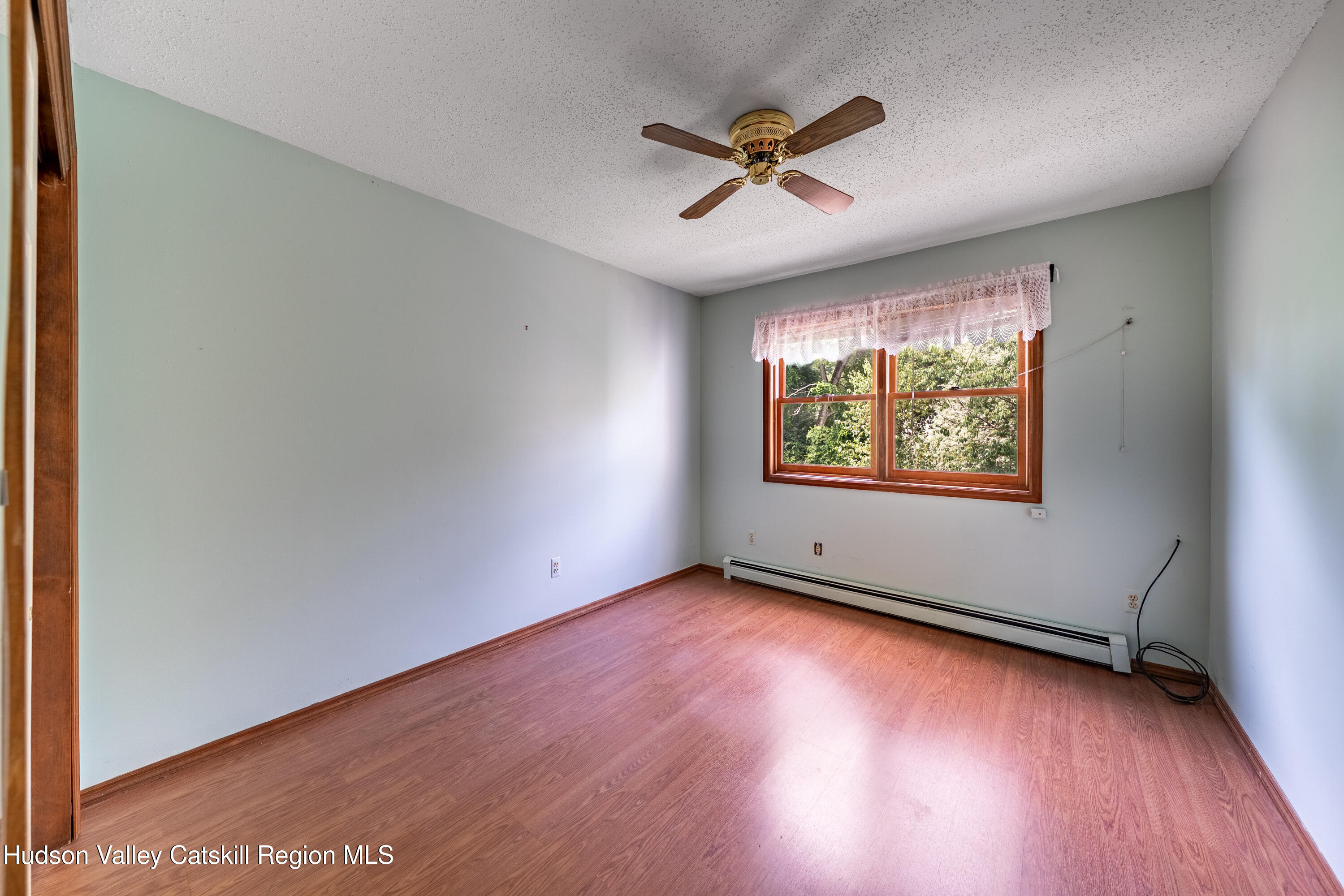 32 Red Maple Road Saugerties, NY 12477 - Photo 22 of 26 an empty room with wooden floor chandelier fan and windows