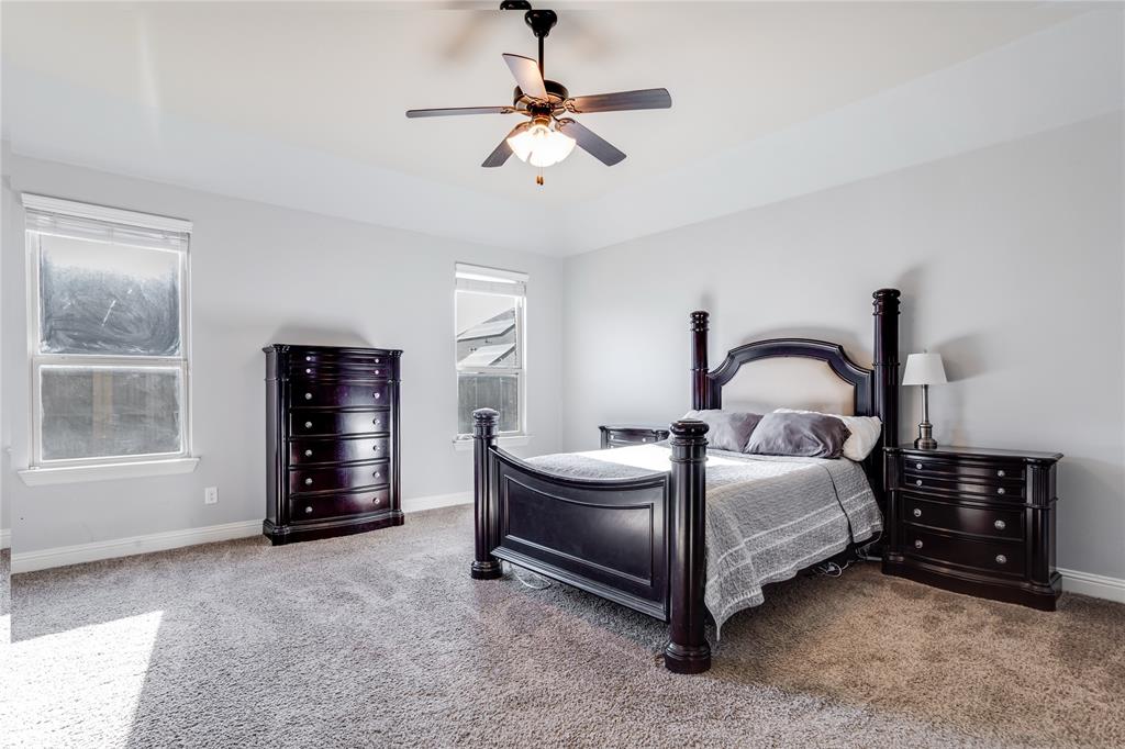 248 Georgetown Drive Forney, TX 75126 - Photo 14 of 39 a bedroom with a bed and a chandelier