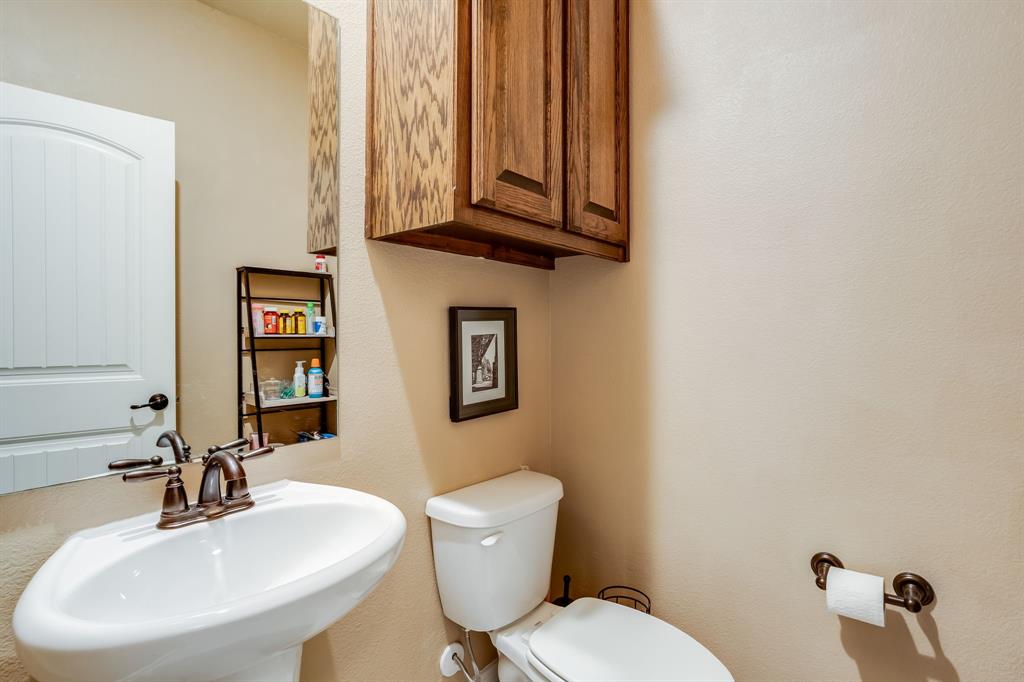 248 Georgetown Drive Forney, TX 75126 - Photo 31 of 39 a bathroom with a toilet a sink and mirror