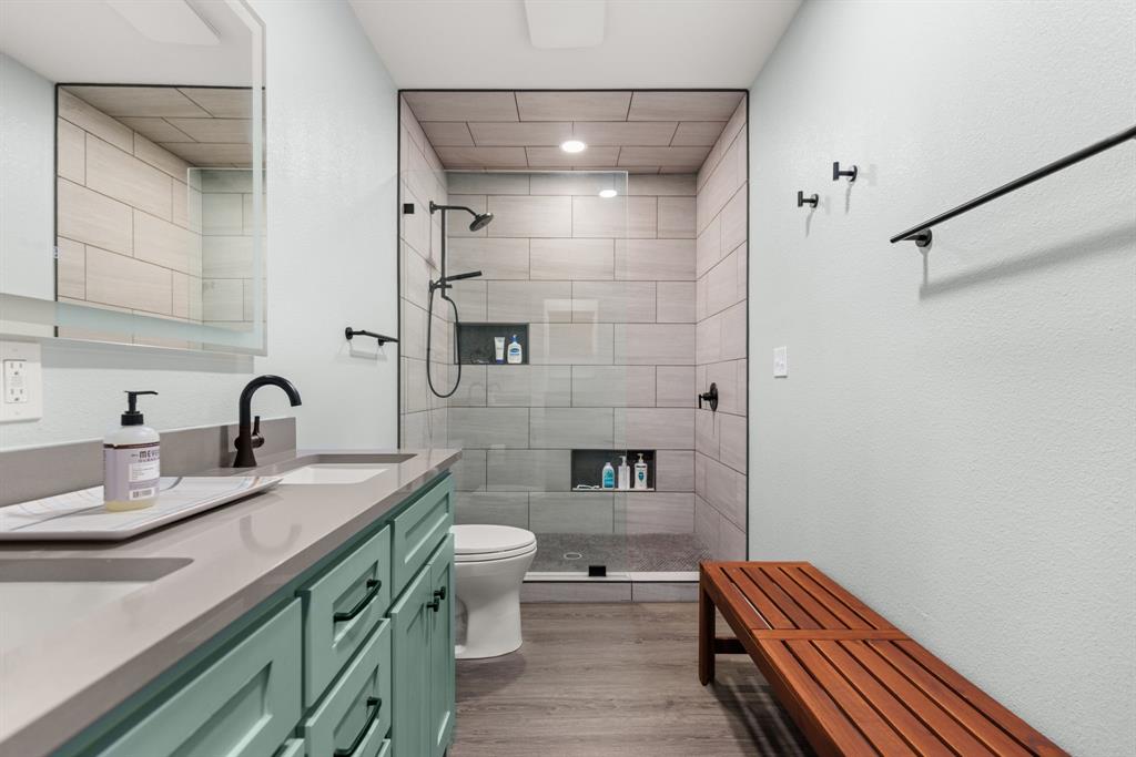 300 Grellhesl Road West, TX 76691 - Photo 19 of 35 a bathroom with a double vanity sink a toilet and shower