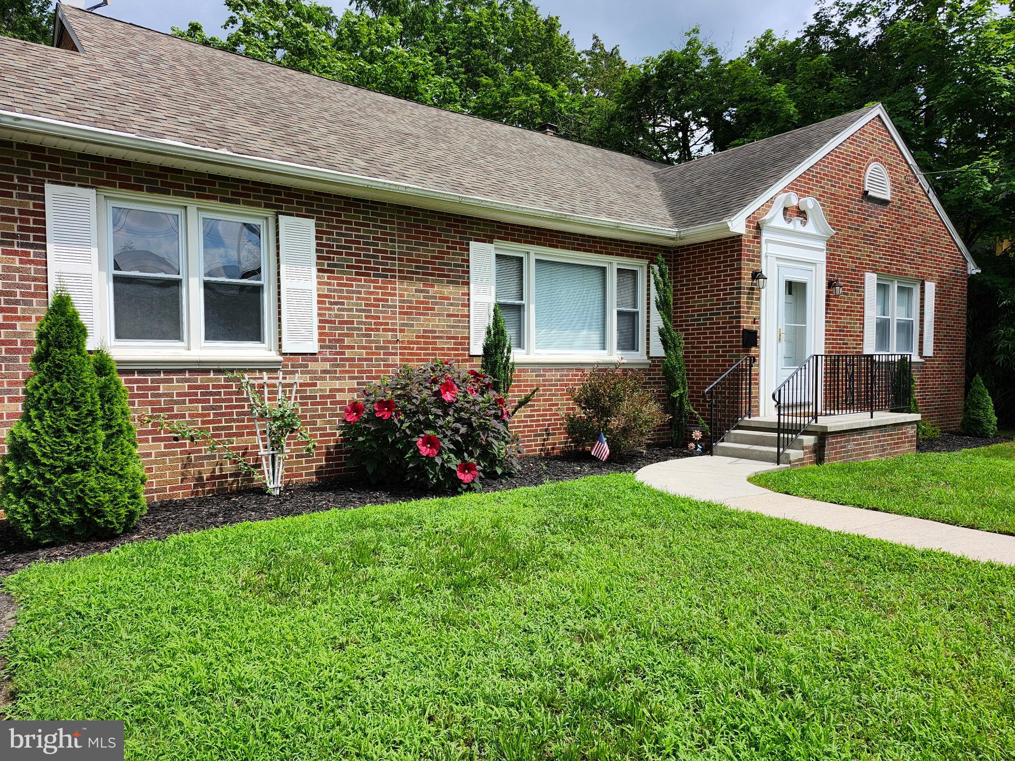 a front view of a house with a garden and plants