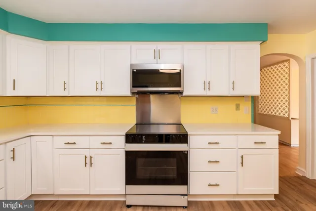 a kitchen with a stove and white cabinets
