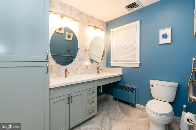 a bathroom with a toilet sink and mirror