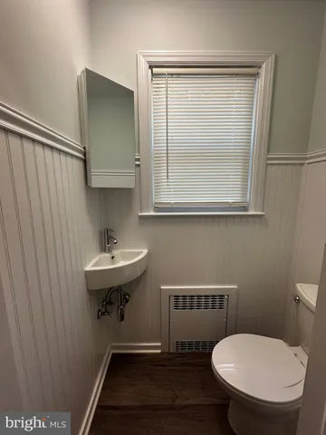a bathroom with a toilet a sink and mirror