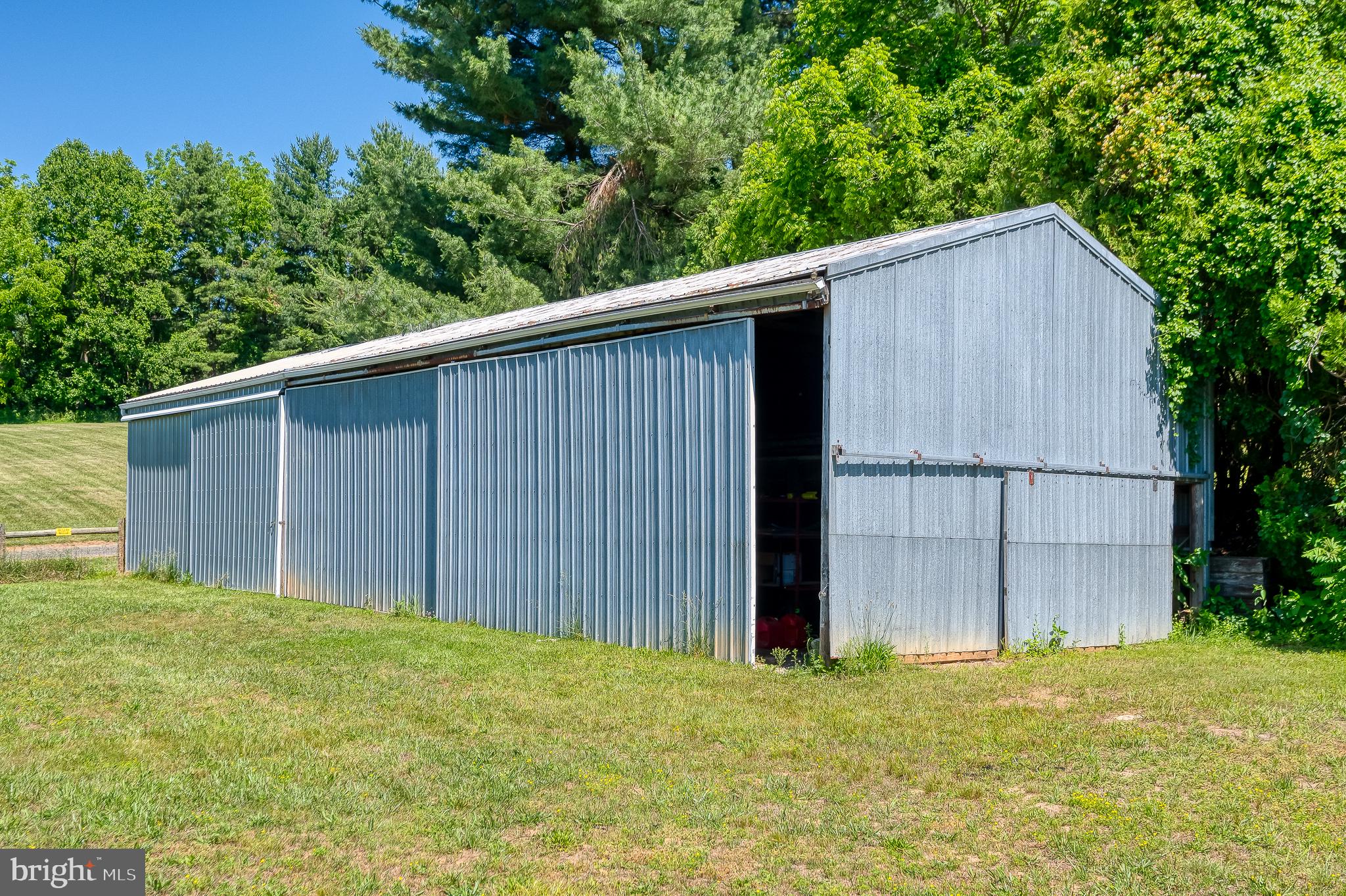 3248 Charles Street Fallston, MD 21047 - Photo 69 of 84 Rustic metal barn amidst lush greenery.