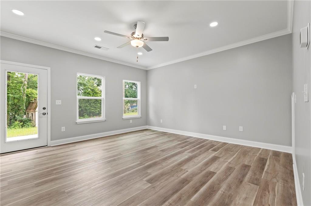5341 Stewart Mill Road Douglasville, GA 30135 - Photo 14 of 36 an empty room with wooden floor fan and windows