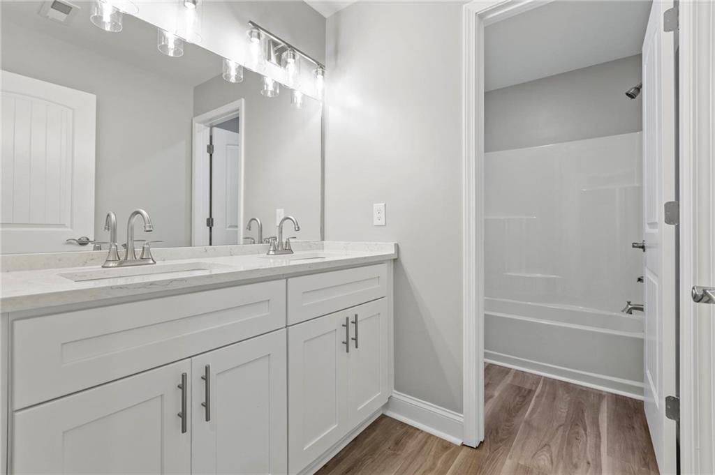 5341 Stewart Mill Road Douglasville, GA 30135 - Photo 29 of 36 a bathroom with a double vanity sink a mirror and a shower