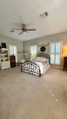 a spacious bedroom with a bed and a chandelier