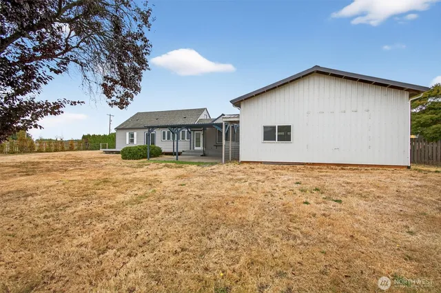 a view of a house with backyard and tree