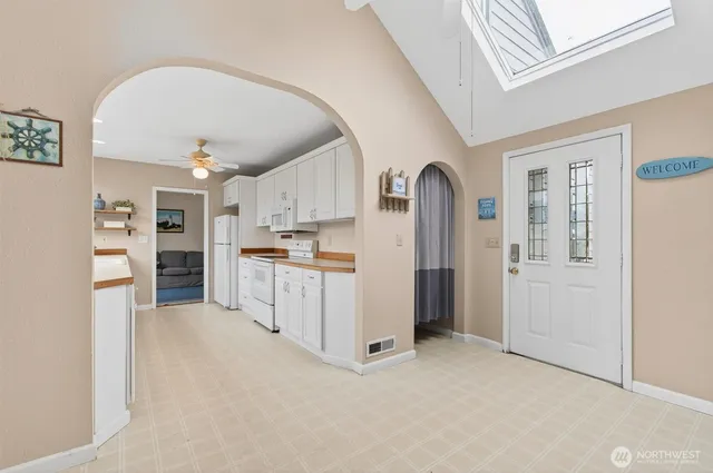 a view of a kitchen with refrigerator and cabinets