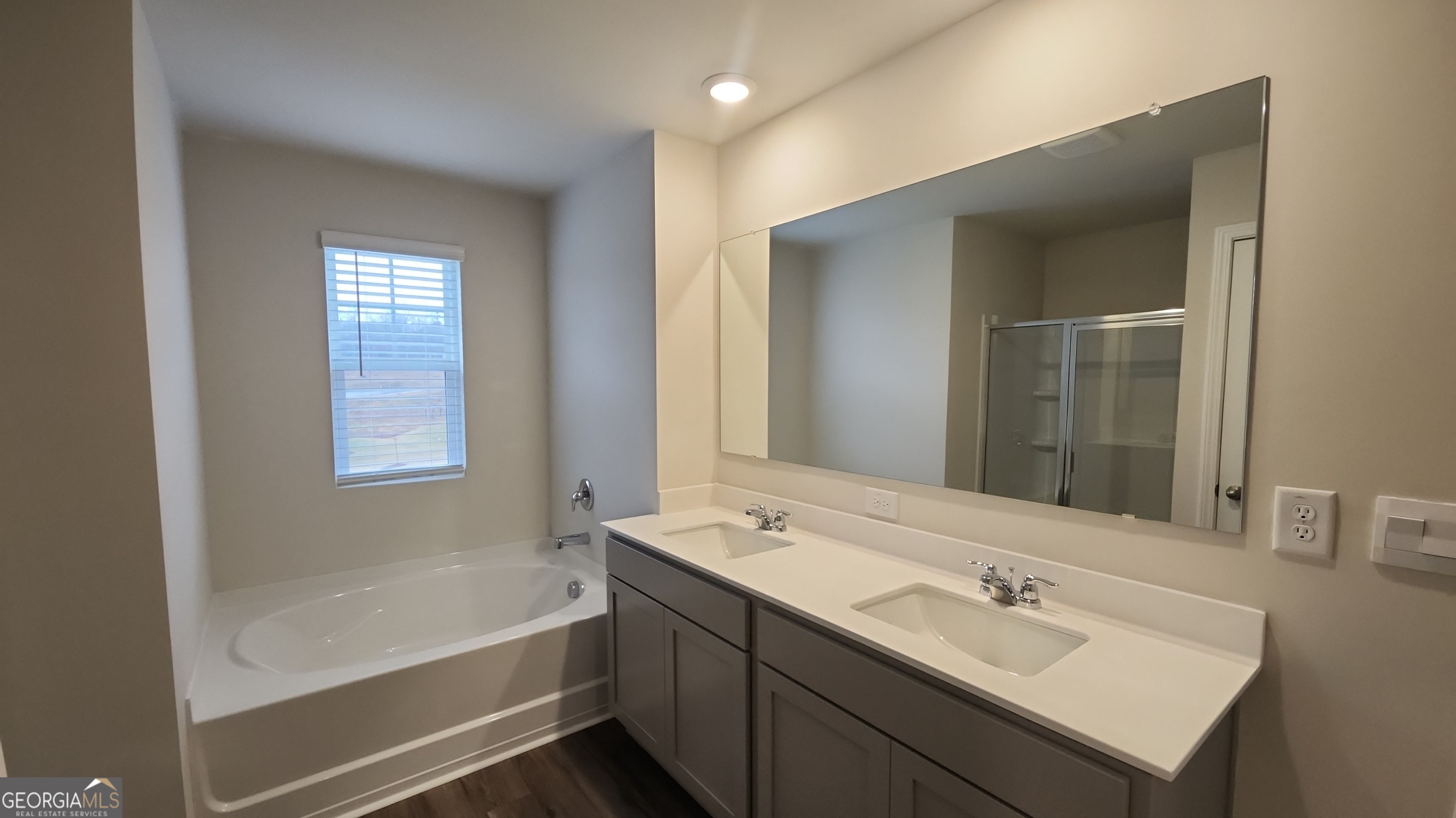 501 Vervain Drive, Unit 174 Locust Grove, GA 30248 - Photo 19 of 33 a bathroom with a tub sink and mirror