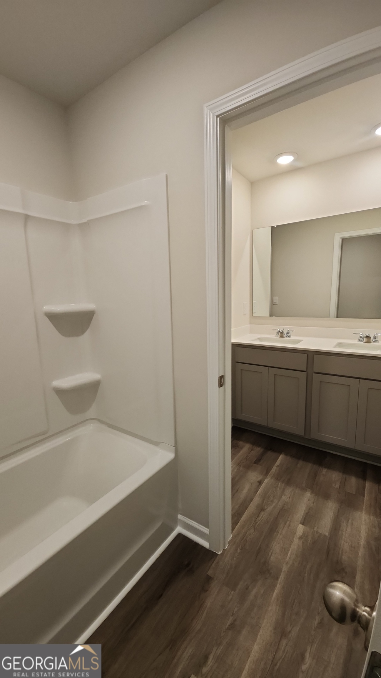 501 Vervain Drive, Unit 174 Locust Grove, GA 30248 - Photo 25 of 33 a bathroom with a tub sink and mirror