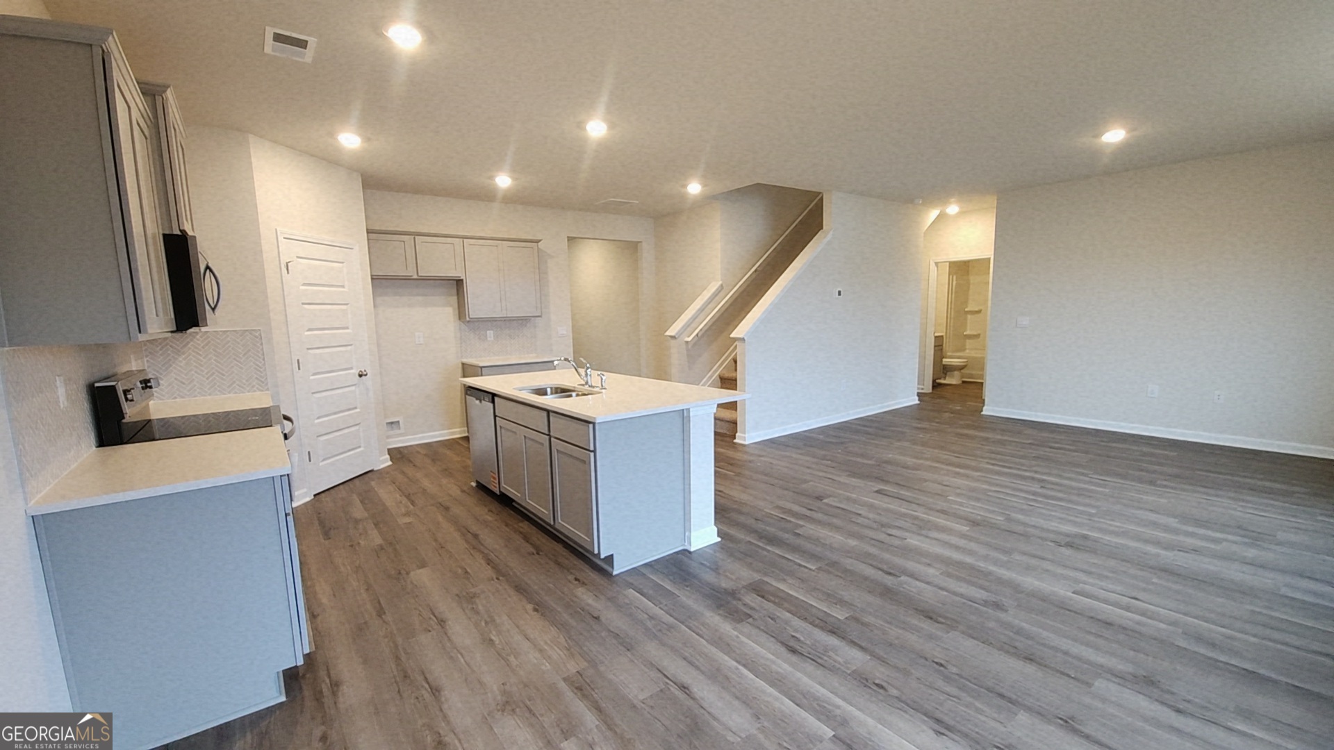 501 Vervain Drive, Unit 174 Locust Grove, GA 30248 - Photo 8 of 33 a large kitchen with a wooden floor and a sink