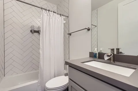 a bathroom with a granite countertop sink toilet and shower
