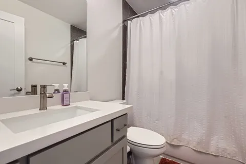 a bathroom with a sink a toilet and shower curtain