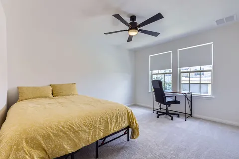 a bedroom with a bed a desk and chair