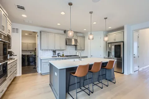 a large kitchen with kitchen island a dining table and chairs