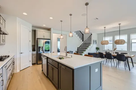a kitchen with a sink a counter and chairs