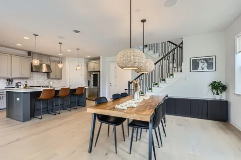a view of a dining room and livingroom with furniture a chandelier