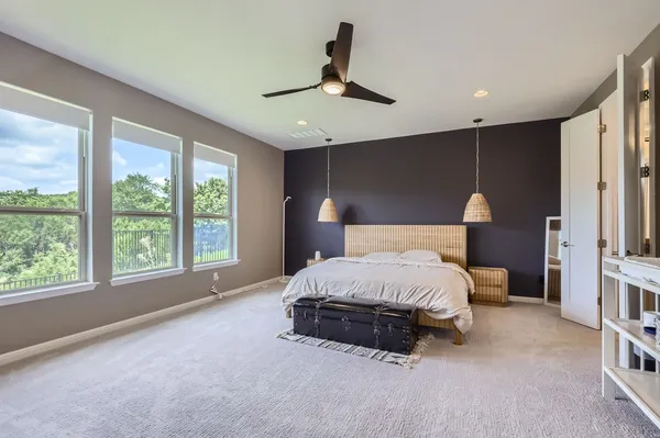 a spacious bedroom with a large bed and a large window