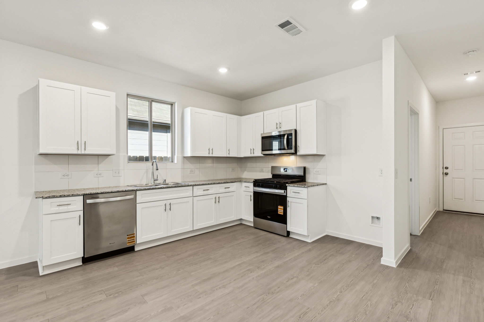 14985 Rustic Moon Road Conroe, TX 77302 - Photo 7 of 32 a kitchen with granite countertop white cabinets and wooden floor