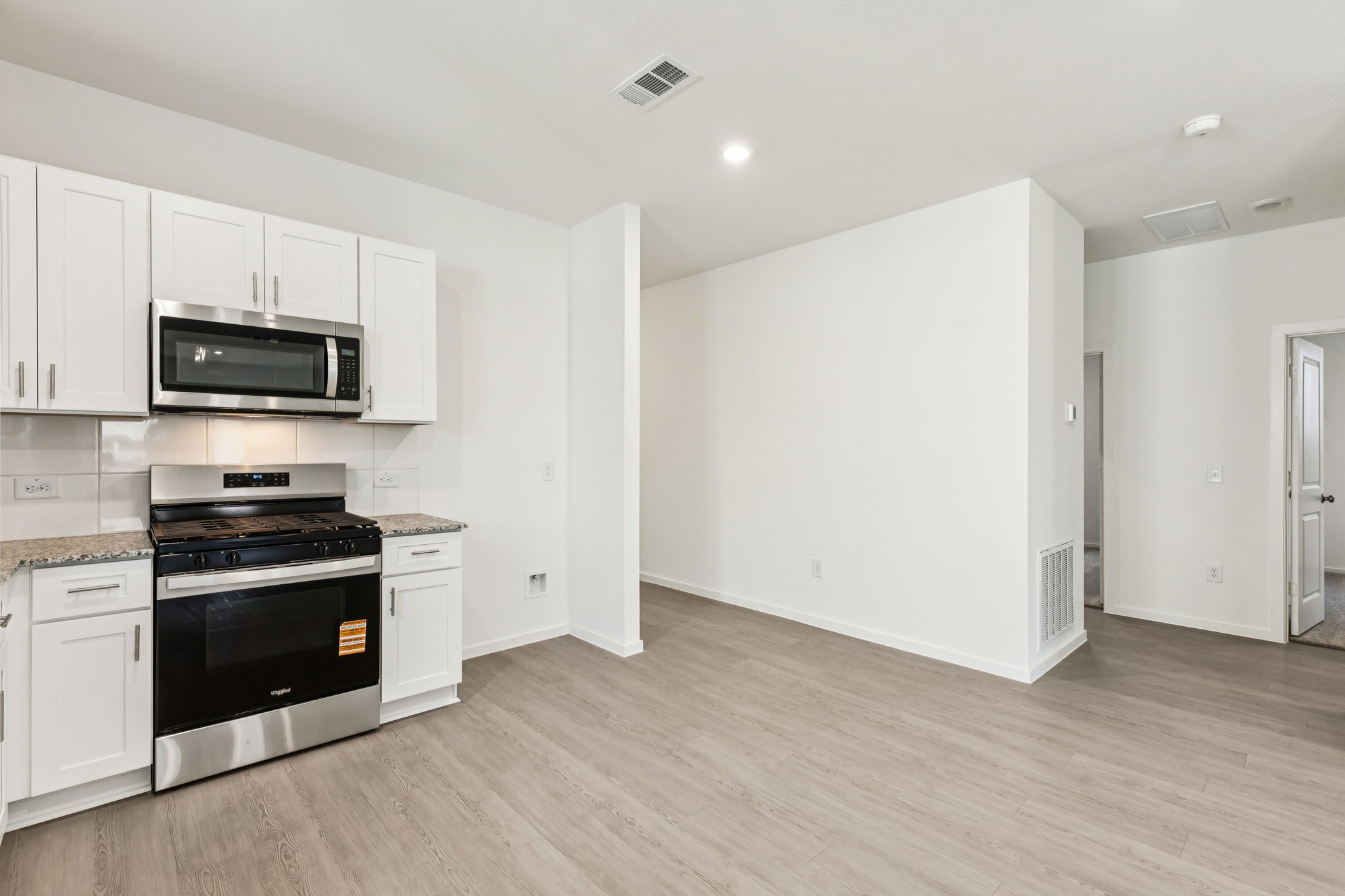 14985 Rustic Moon Road Conroe, TX 77302 - Photo 8 of 32 a kitchen with stainless steel appliances a stove microwave and sink