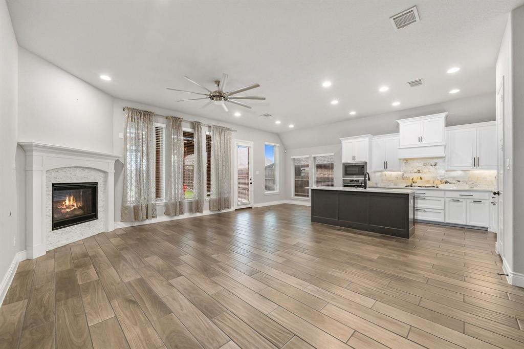1501 Calcot Lane Forney, TX 75126 - Photo 11 of 34 Open-concept living space featuring wood-finish flooring, a fireplace