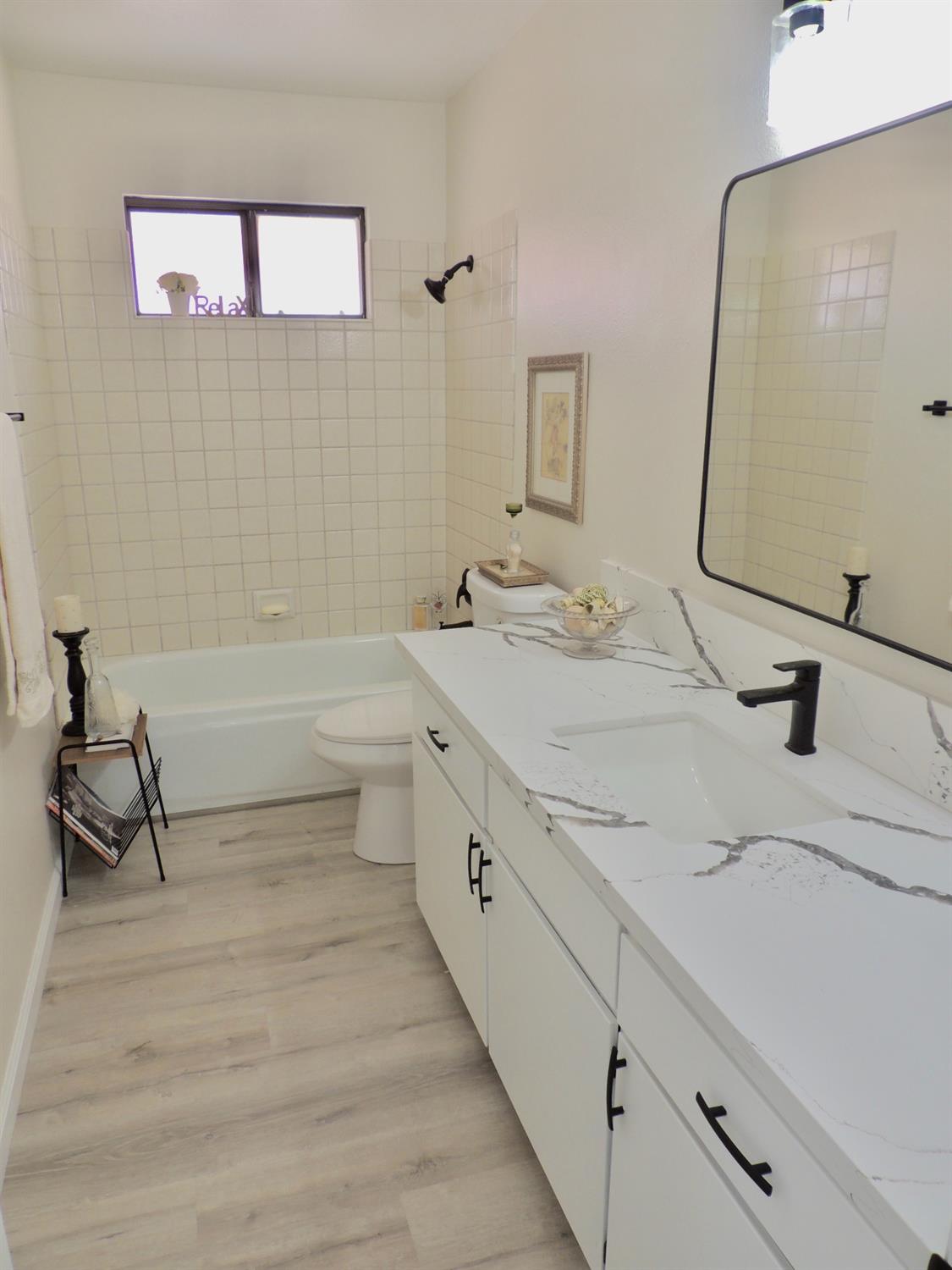 2395 Keats Avenue Clovis, CA 93611 - Photo 13 of 22 a bathroom with a double vanity sink a mirror and a bathtub