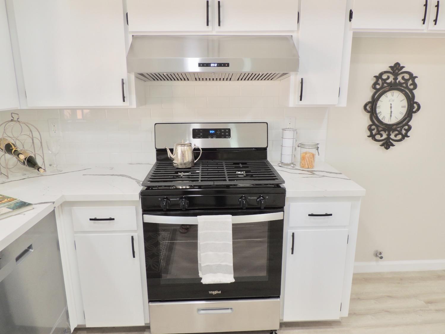 2395 Keats Avenue Clovis, CA 93611 - Photo 5 of 22 a white kitchen with stainless steel appliances granite countertop a stove and white cabinets