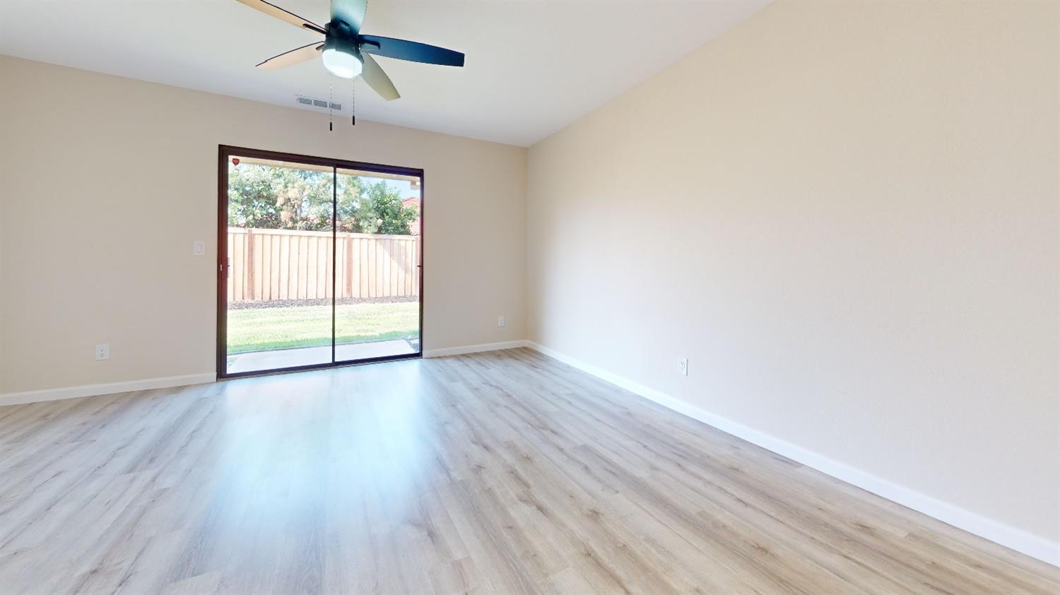2395 Keats Avenue Clovis, CA 93611 - Photo 9 of 22 an empty room with wooden floor fan and windows