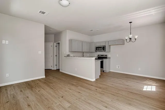 a view of kitchen with refrigerator microwave and cabinets