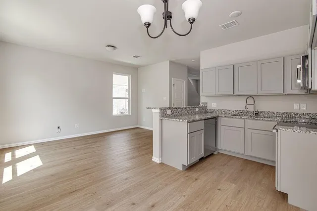 a kitchen with granite countertop white cabinets and white appliances