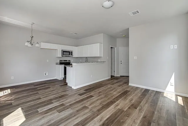 a view of a kitchen with a dishwasher and wooden floor