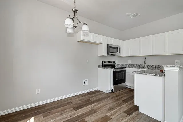 a kitchen with a cabinets and wooden floor