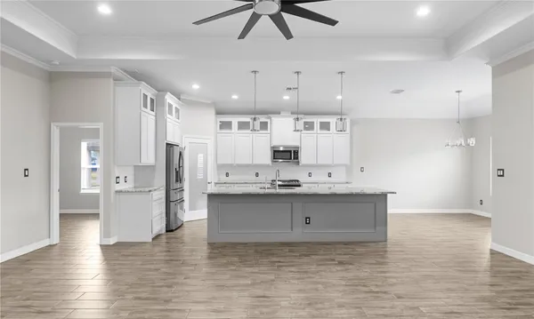 a view of kitchen with stainless steel appliances refrigerator stove microwave and cabinets