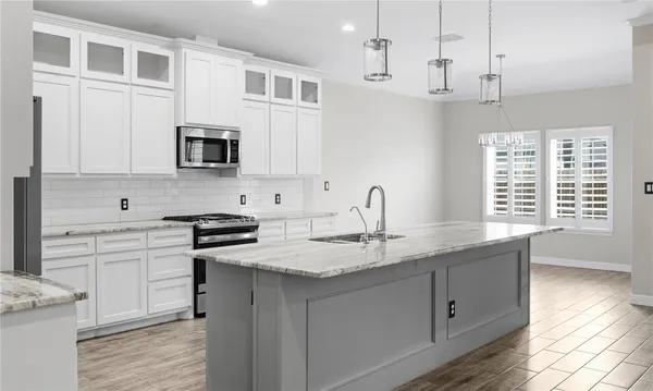 a kitchen with stainless steel appliances granite countertop a sink stove and cabinets