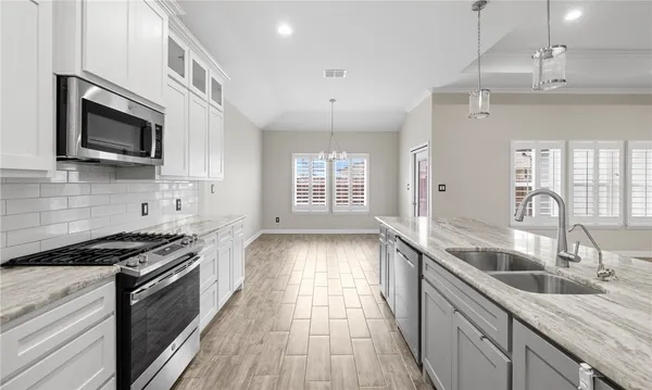 a kitchen with stainless steel appliances granite countertop a sink stove and microwave