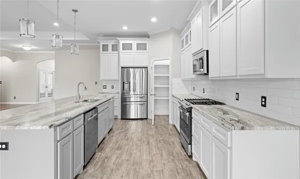 a kitchen with stainless steel appliances granite countertop a sink stove and refrigerator
