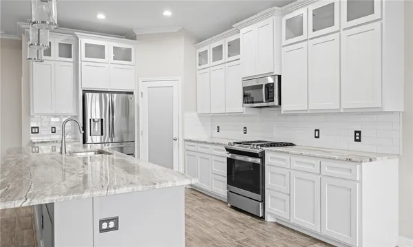 a kitchen with stainless steel appliances granite countertop a stove and cabinets