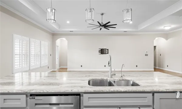 a kitchen with a granite countertop sink and dishwasher with wooden floor