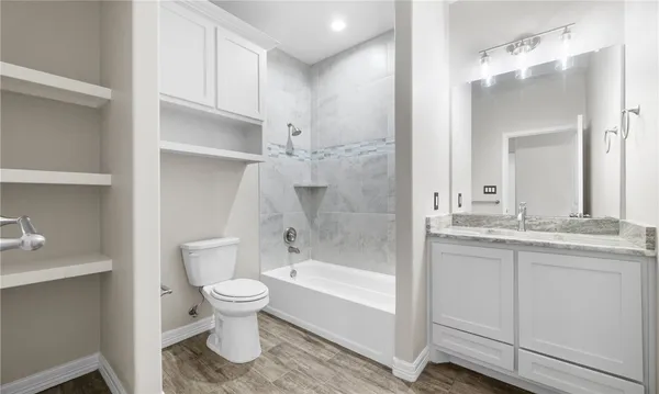a bathroom with a granite countertop sink toilet and shower
